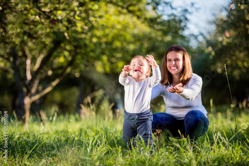 Fotografija Mother with her son making first steps, green nature