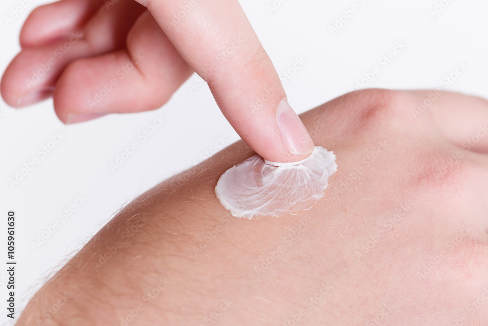 Fototapeta premium Mann cremt sich die Hand mit Schutzcreme ein