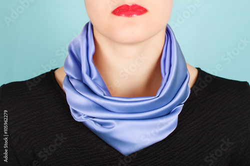 Silk scarf. Blue silk scarf around her neck isolated on blue background.
