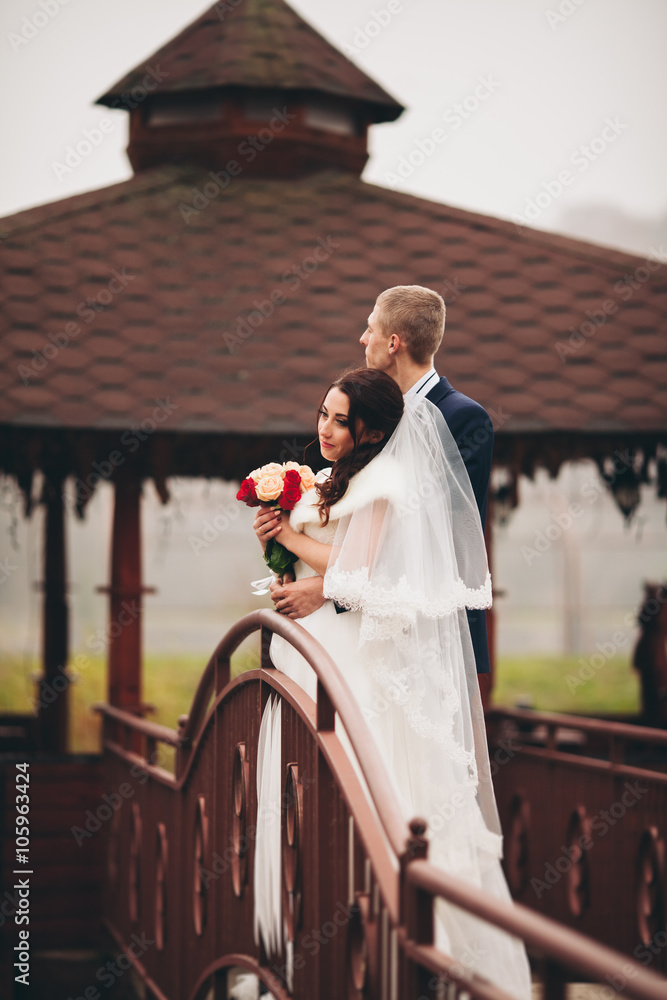 Obraz premium Happy wedding couple, bride and groom posing in park autumn