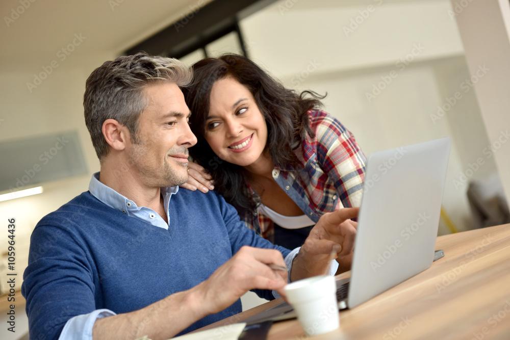 Couple at home using laptop computer Couple at home using laptop computer
