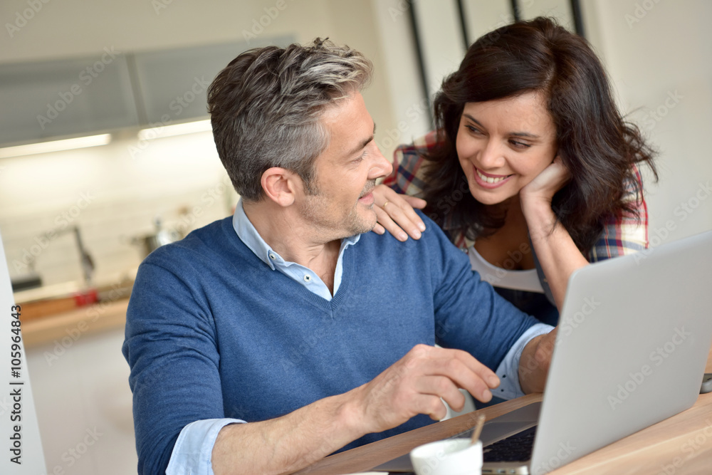 Couple at home using laptop computer Couple at home using laptop computer
