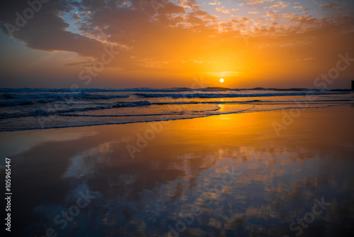 Beach with glossy surface reflecting beautiful seascape on the sunset in Maspalomas on Gran Canaria island