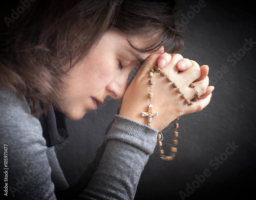 woman praying with rosary