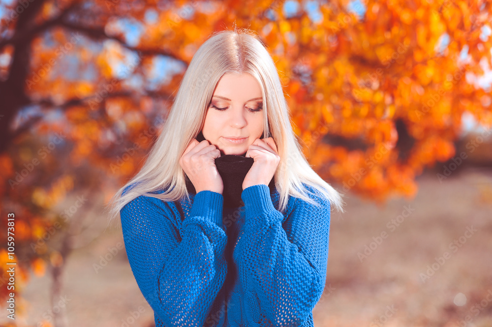 Beautiful blonde woman with eyes closed outdoors. Wearing knitted sweater. Eyes closed. 20s. Beautiful blonde woman with eyes closed outdoors. Wearing knitted sweater. Eyes closed. 20s.