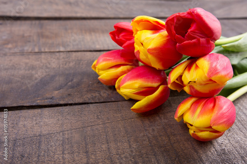 Fototapeta Naklejka Na Ścianę i Meble -  Color tulips on wooden background with copy space for message. Top view. For Mother's Day, Woman's day or Wedding day