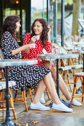 Canvas Print Beautiful twin sisters drinking coffee