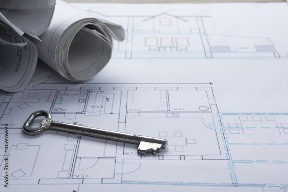 Architect worplace top view. Architectural project, blueprints, blueprint rolls and divider compass, key, blank business card on plans. Construction background. Engineering tools. Copy space Architect worplace top view. Architectural project, blueprints, blueprint rolls and divider compass, key, blank business card on plans. Construction background. Engineering tools. Copy space