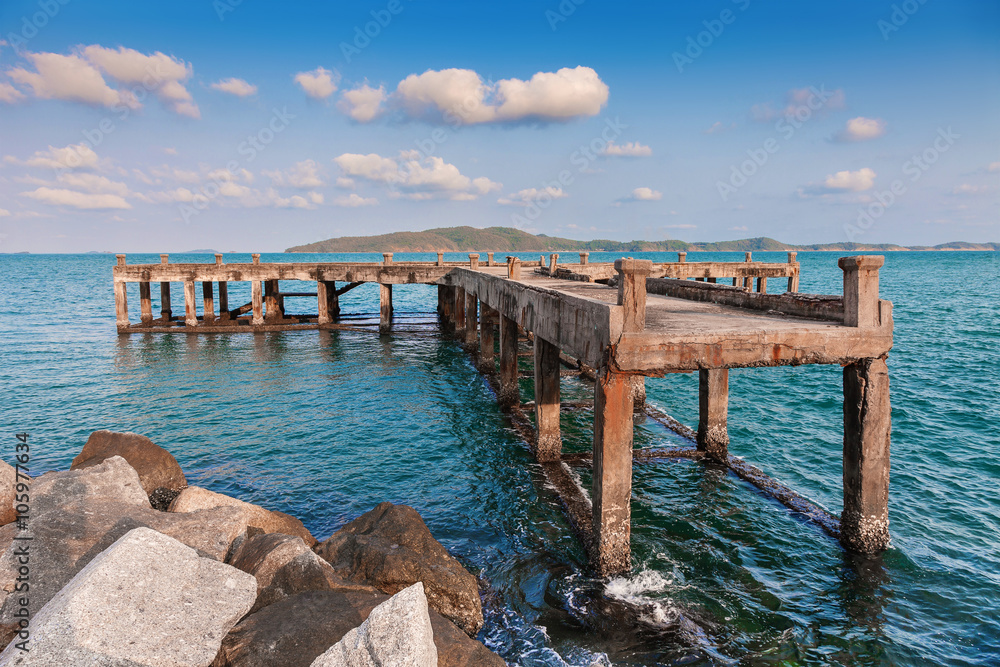 old pier bridge in the calmness sea with blue sky
