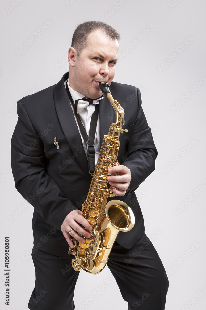 Fototapeta premium Portrait of Expressive Caucasian Player in Suit Playing on Saxophone