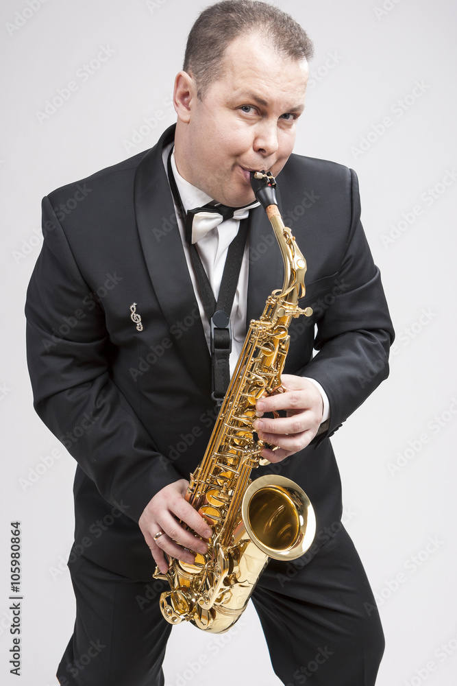 Fototapeta premium Portrait of Expressive Caucasian Player in Suit Playing on Saxophone