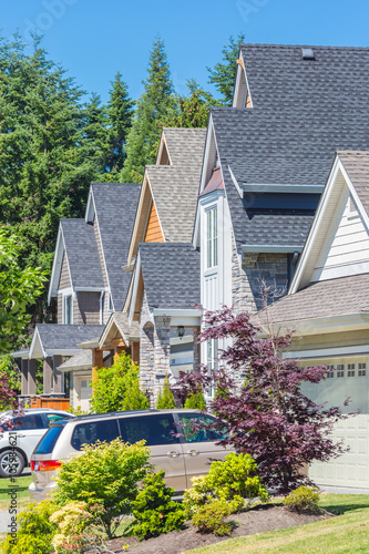 Custom built luxury houses in a residential neighborhood in North America on a sunny day.