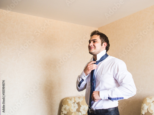 Well dressed business man adjusting his neck tie photo