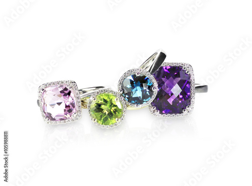 Scattered gemstone and diamond halo fine jewelry rings in a grouping