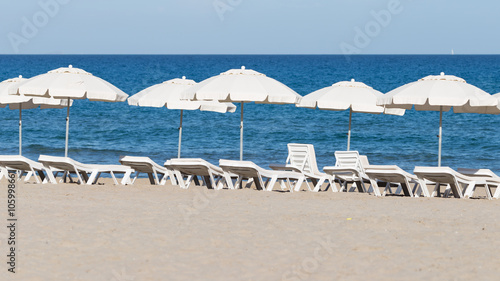 chairs with white umbrellas on the beach