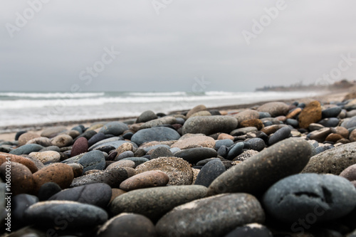 Low angle of stones scattered over the beach at South Carlsbad State Beach in San Diego, California.