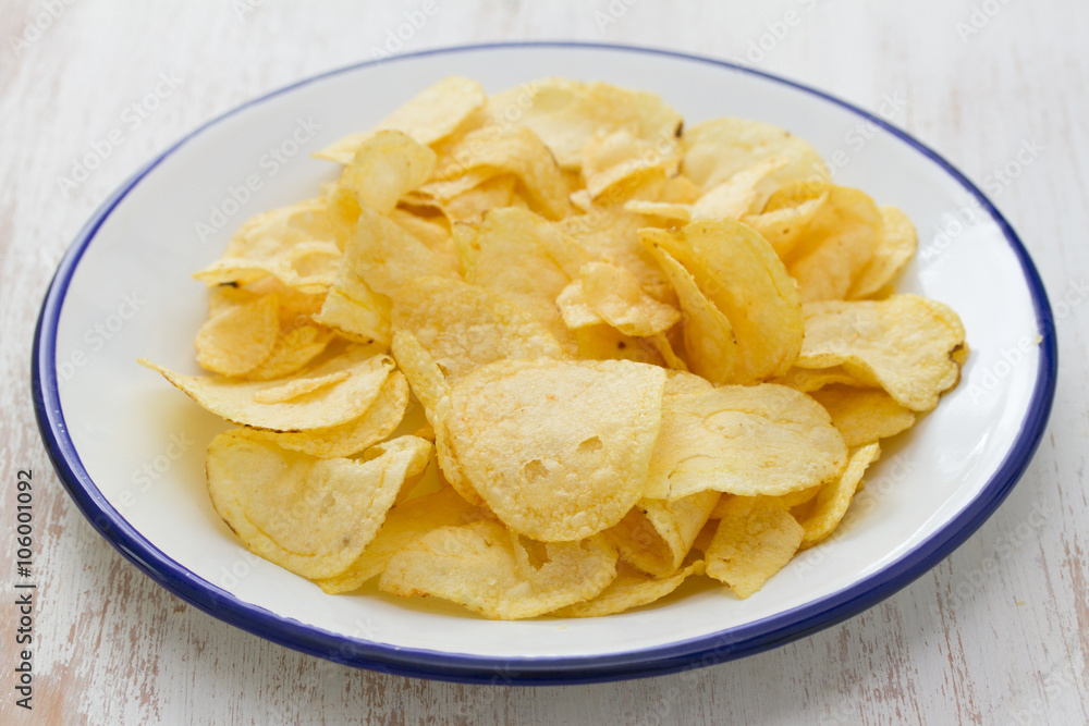 potato chips on white plate on white wooden background potato chips on white plate on white wooden background