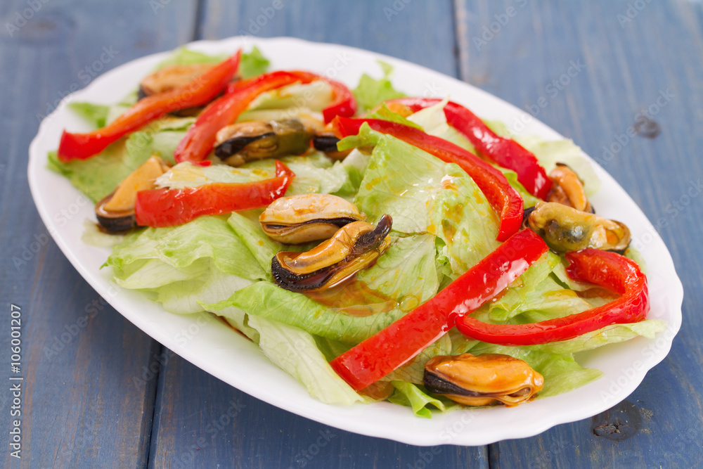 salad with seafood in white dish on blue wooden background salad with seafood in white dish on blue wooden background