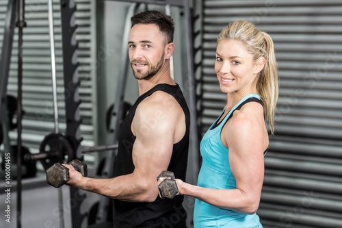 Couple posing with dumbbells