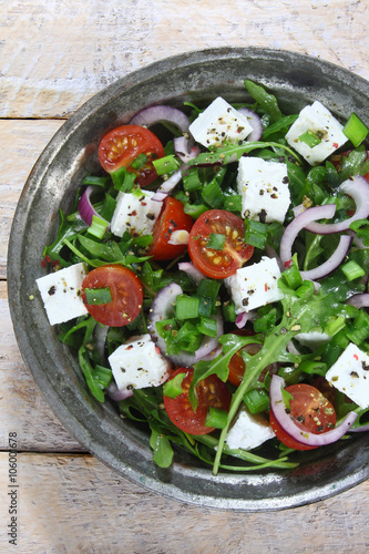 Salad with arugula, tomato, cheese and red onion