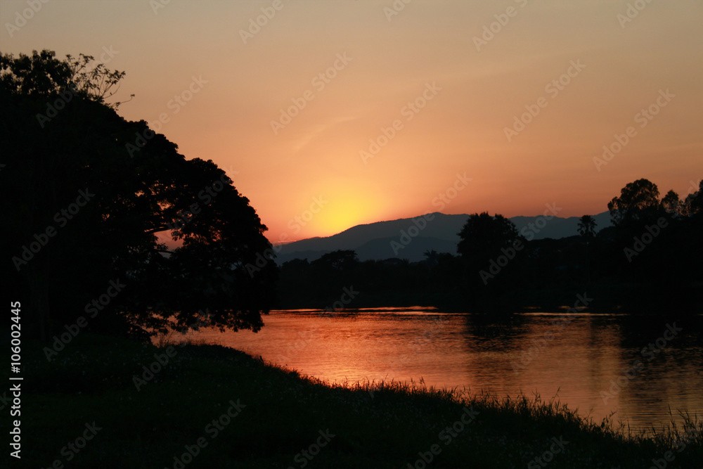 Sun sets with mountain and river