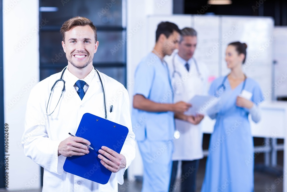 Doctor holding medical report and smiling at camera Doctor holding medical report and smiling at camera