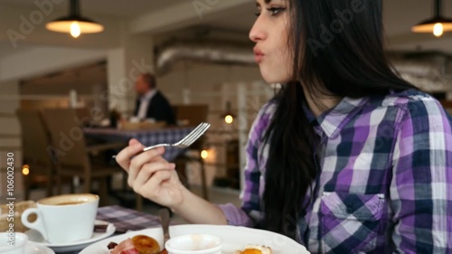 Young girl eating breakfast in the restaurant. 