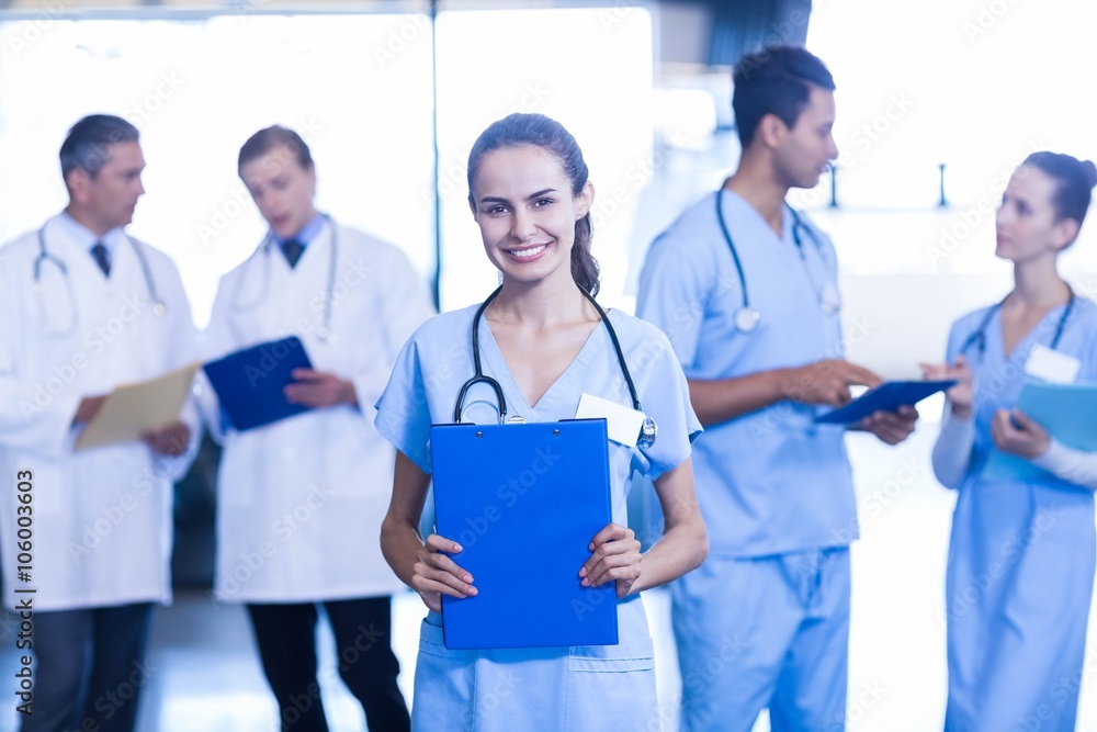 Female doctor holding medical report and smiling at camera Female doctor holding medical report and smiling at camera