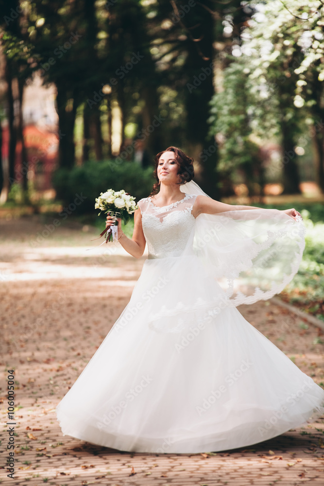 Beautiful luxury bride posing with a bouquet outdoors Beautiful luxury bride posing with a bouquet outdoors