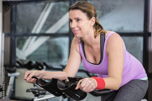 Smiling woman using exercise bike © WavebreakMediaMicro
