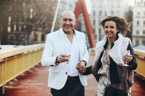 stylish beautiful happy bride and groom walking and run with gob photo