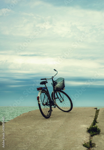 Fototapeta Naklejka Na Ścianę i Meble -  Bicycle at the beach on cloudy sky background. vintage retro sty