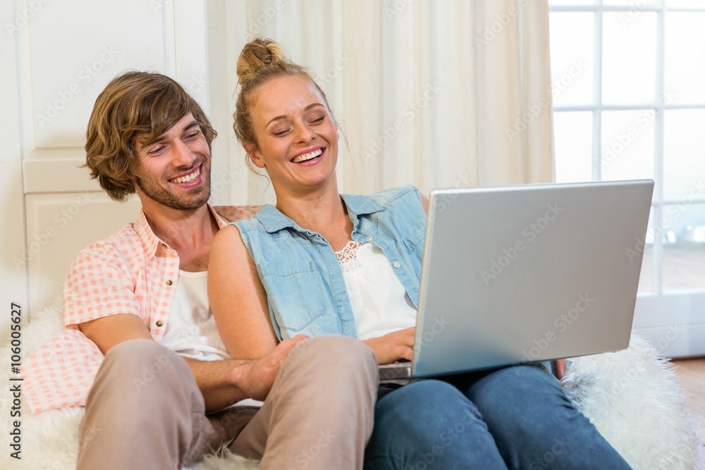 Cute couple using laptop sitting on the couch Cute couple using laptop sitting on the couch