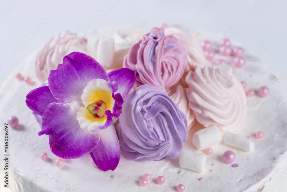 orchid flower on the cake with white cream and marshmallows orchid flower on the cake with white cream and marshmallows