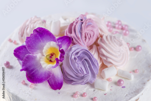 orchid flower on the cake with white cream and marshmallows