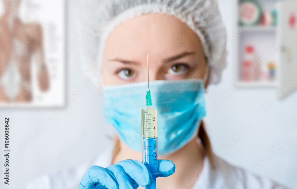 Nurse or female doctor holding an injection needle . Nurse or female doctor holding an injection needle .
