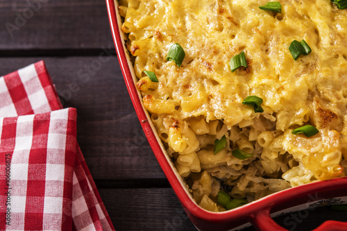 Casserole with pasta and white cabbage on a black wood background 