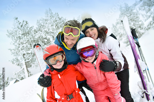 Portrait of happy family of skiers in snowy mountain