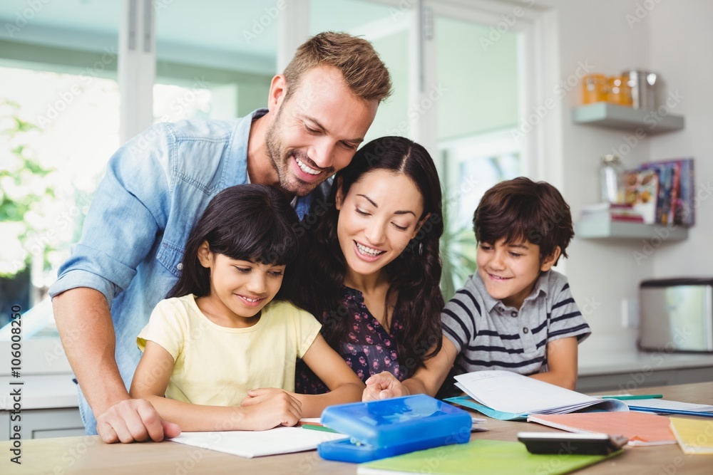 Happy parents assisting children doing homework 