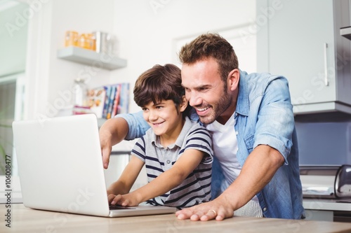 Father and son using laptop 