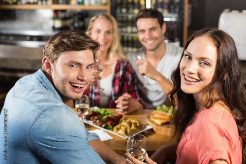 Smiling friends drinking white wine