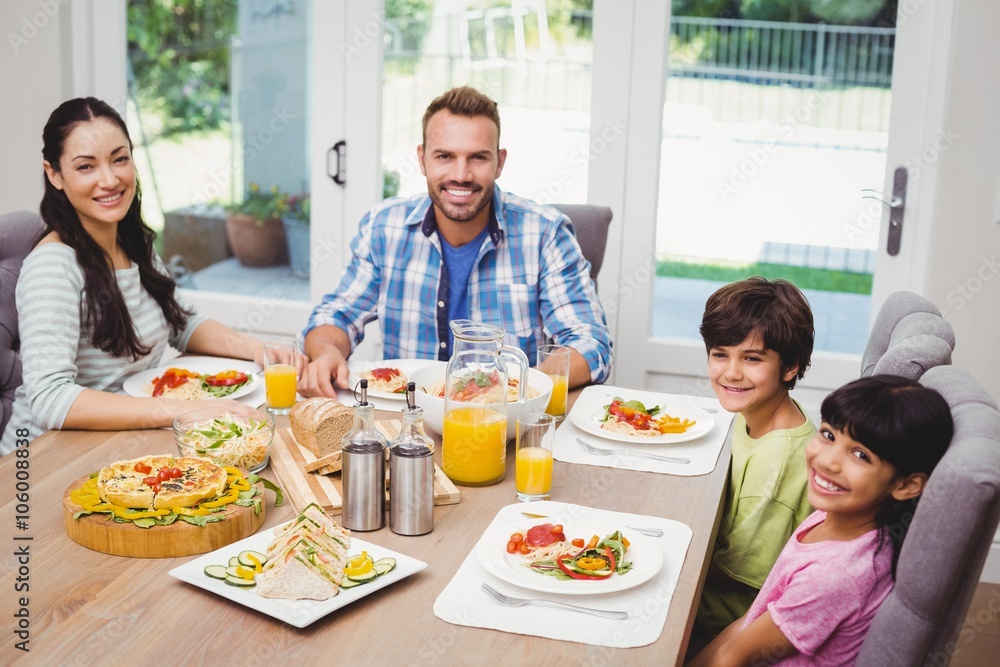 Portrait of smiling family sitting at dining table Portrait of smiling family sitting at dining table