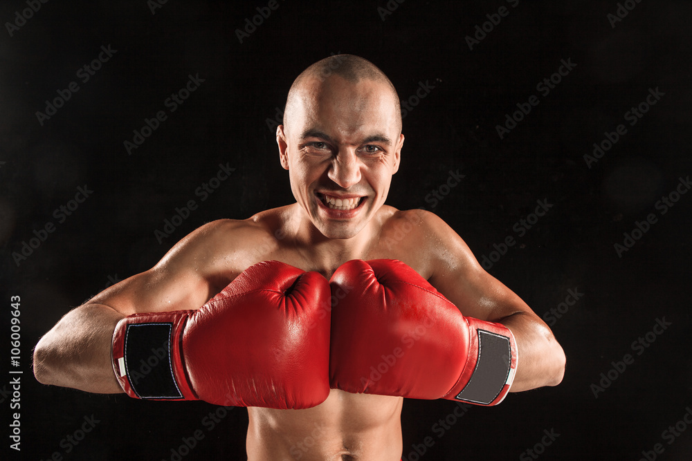 The young man kickboxing on black  with screaming face