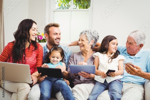 Family smiling while holding technologies 