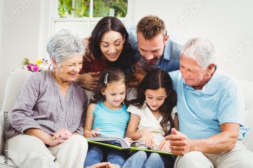 Family assisting girls while reading book 