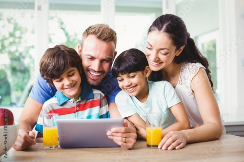 Smiling family using digital tablet 