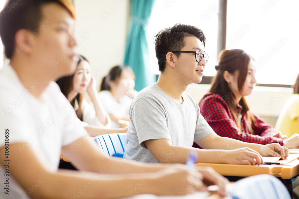 smiling male college student sitting with classmates smiling male college student sitting with classmates