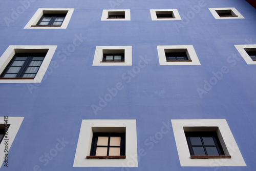Biale okna na niebieskiej scianie