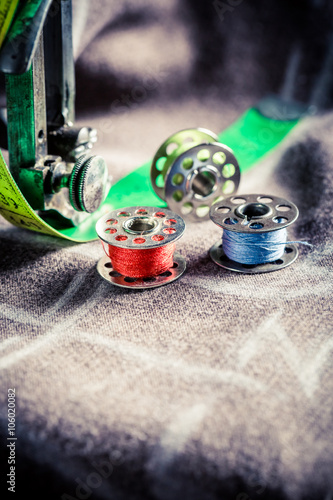 Old sewing machine with scissors, threads and cloth