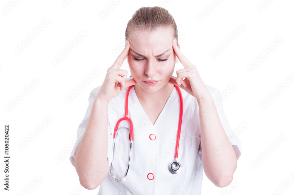 Woman doctor holding her head in pain looking exhausted Woman doctor holding her head in pain looking exhausted